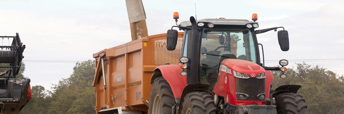 Combine harvester unloading grain into trailer