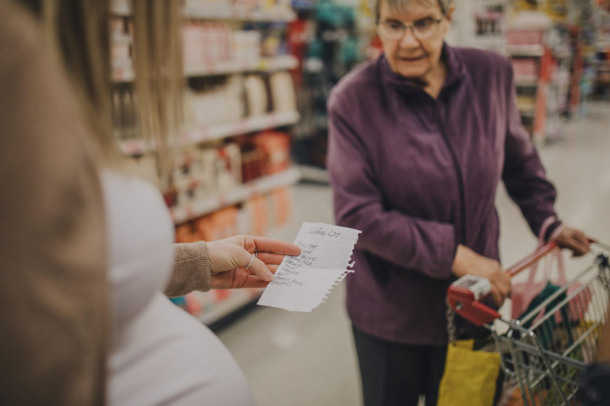 Pregnant Woman Shopping with Grandmother holding shopping list