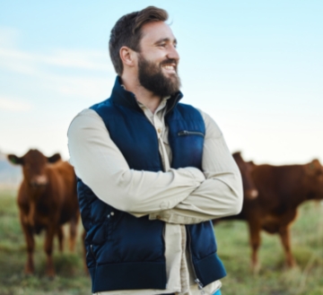 Farmer with cows in the background